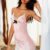 Woman in a pink satin lingerie chemise with lace trim and a black bow posing by a window. Woman in a pink satin lingerie chemise with lace trim and a black bow posing by a window.